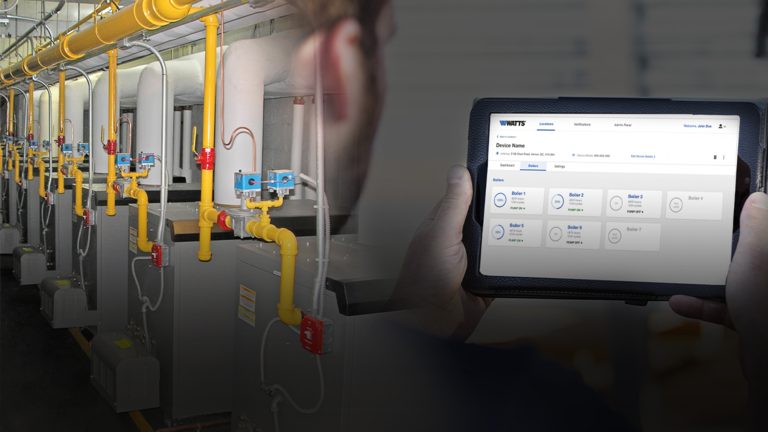man holding tablet that is showing a monitoring screen for his boiler system.